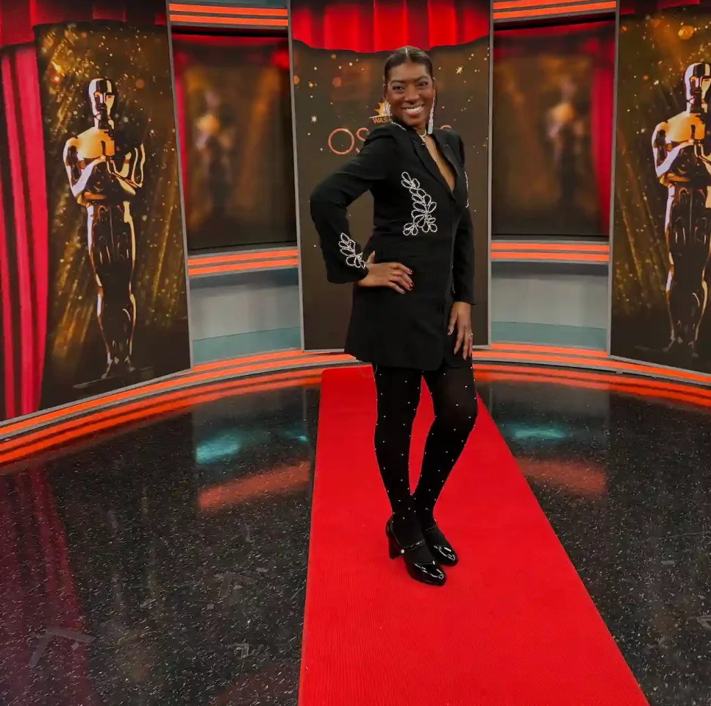 Person posing on red carpet with Oscar backdrop